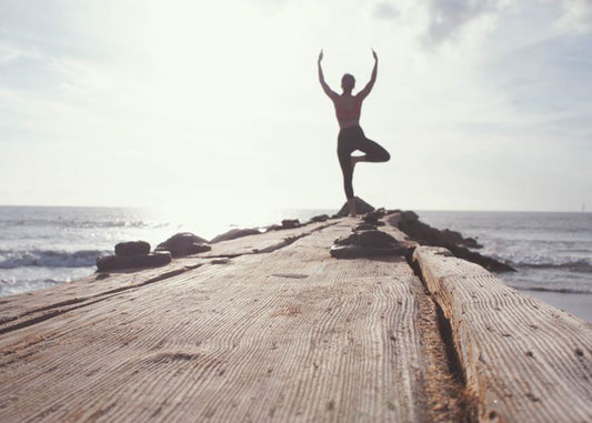Woman doing yoga on a dock